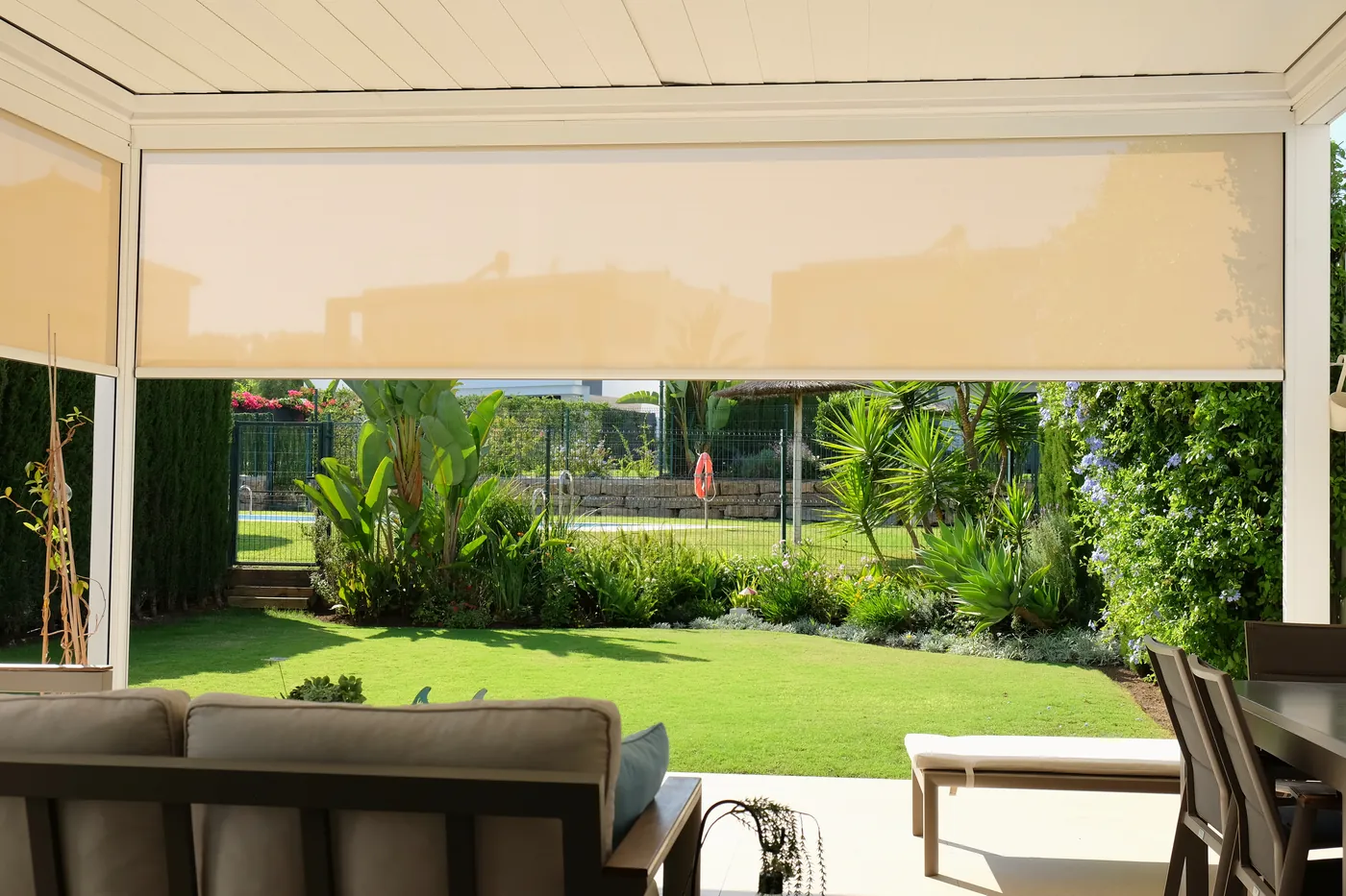 Terraza cubierta bajo la pérgola bioclimática, frente al jardín